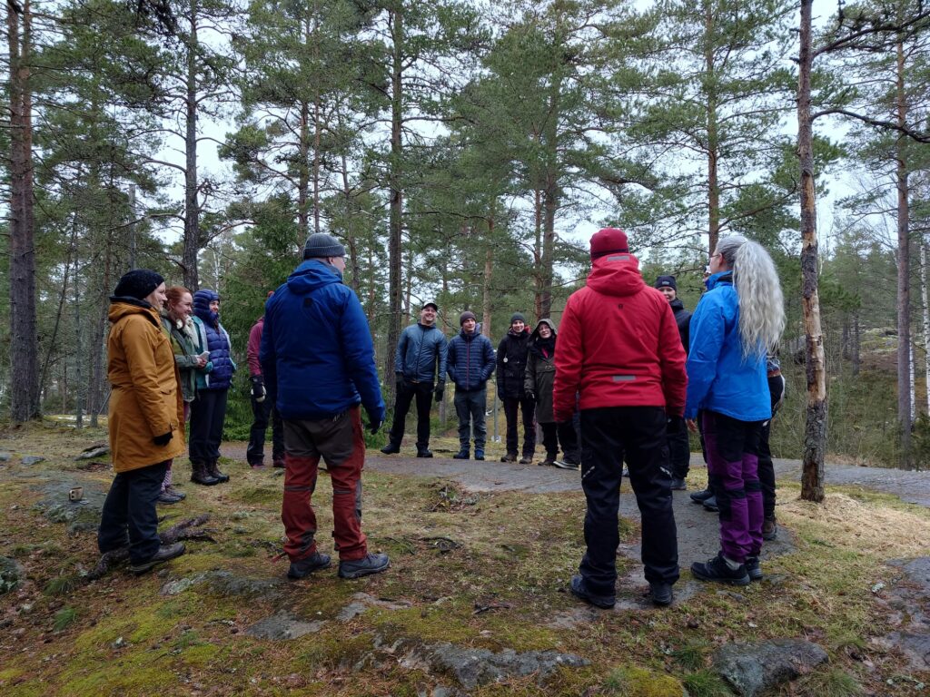 Seikkailuterapiaverkoston kevättapaaminen, paljon ihmisiä ringissä ulkona.