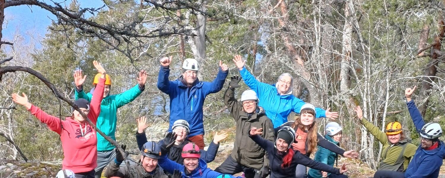 Porukkakuva luolaseikkailun jälkeen kalliolla.