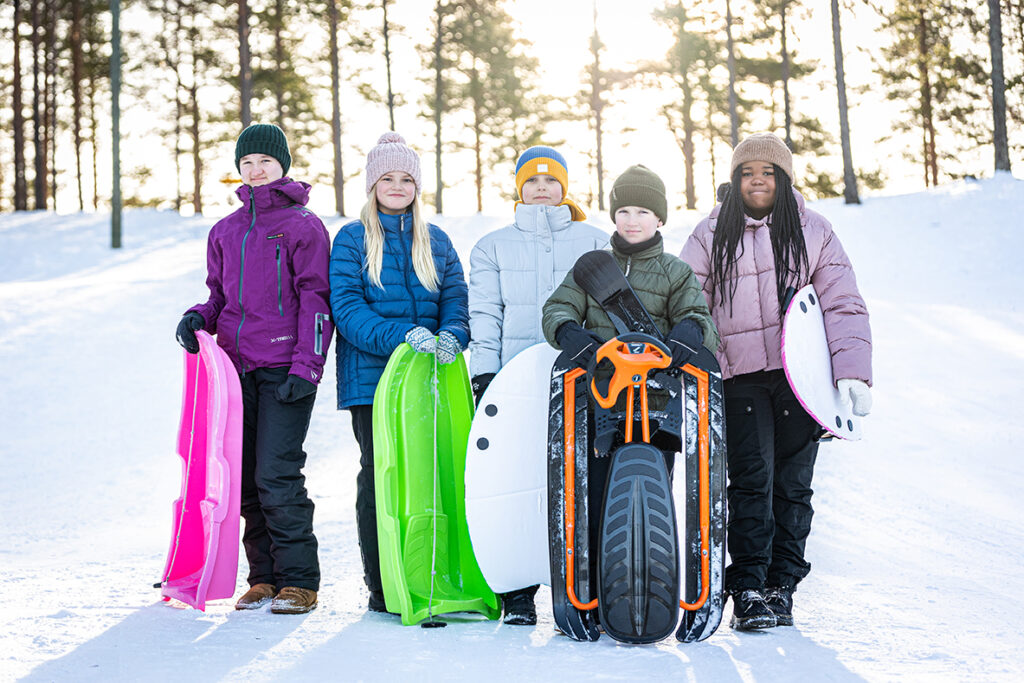 Ryhmäkuva leirikoulussa olevista lapsista pulkkamäessä.